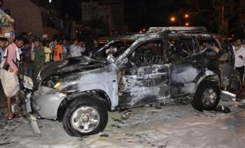 سكان محليون يتجمعون حول سيارة العميد عمر سالم بارشيد بعد ان تفحمت في المكلا بجنوب اليمن يوم الخميس. رويترز