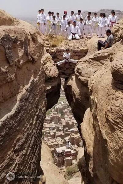 صورة مرعبة لطفل يمني يغامر بالوقوف بطريقة مرعبة بين جبلين (شاهد)