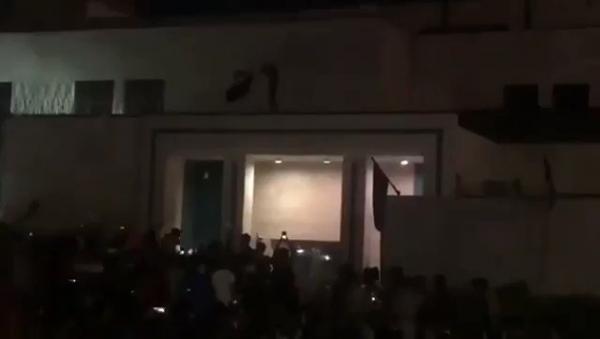 اقتحام قنصلية إيران في كربلاء وانزال علمها ورفع علم العراق.. واحراق صور خامنئي (فيديو)