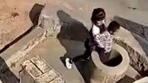 بغرض اللعب. طفلة تلقي صبي صغير ببئر عميق 