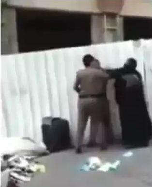 شاهد بالفيديو(قبل الحذف) شرطي سعودي يعتدي على سيدة وسط الشارع ويحاول نزع غطاء رأسها